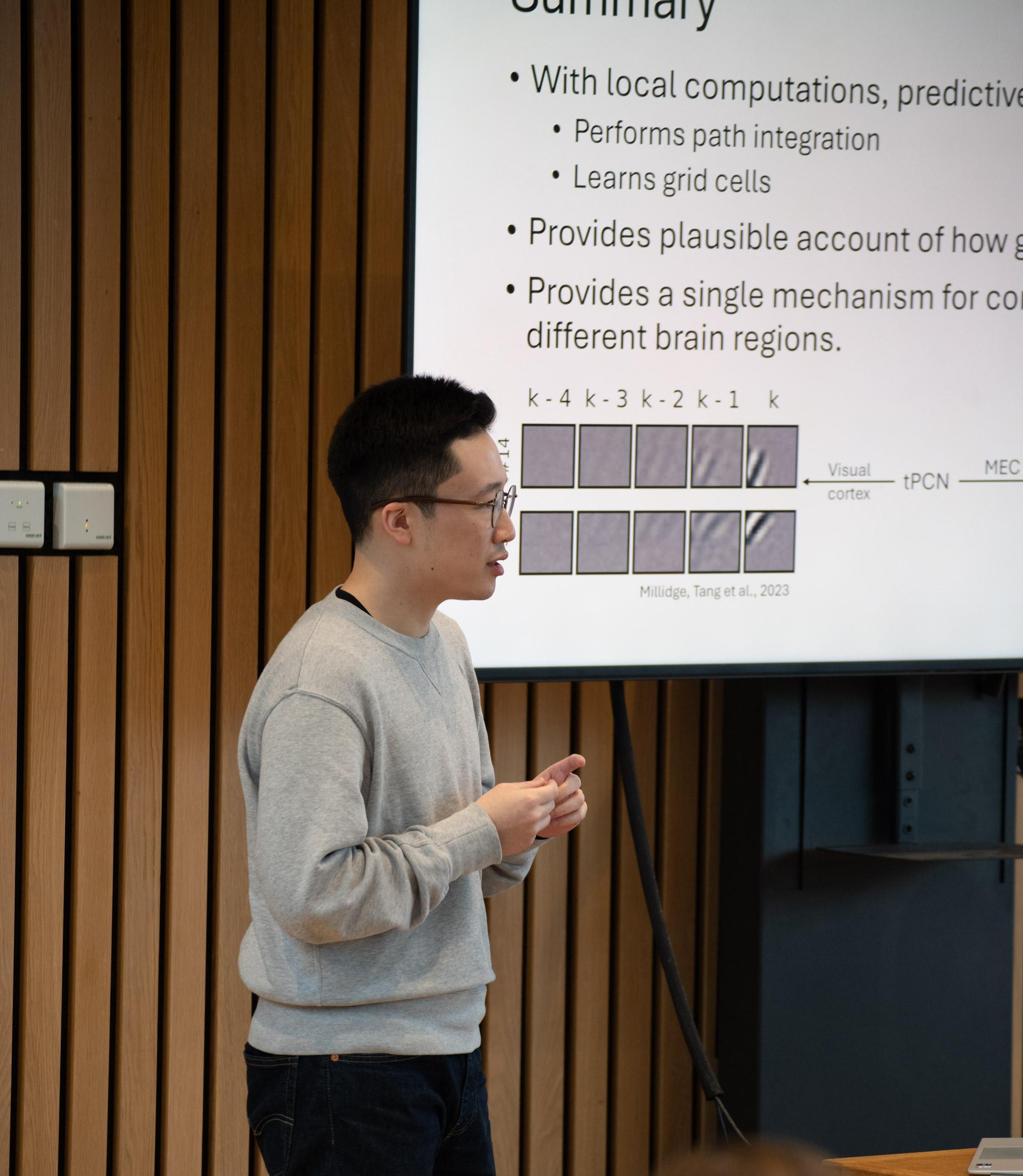 A photo of Mufeng Tang presenting his research to Unit colleagues.