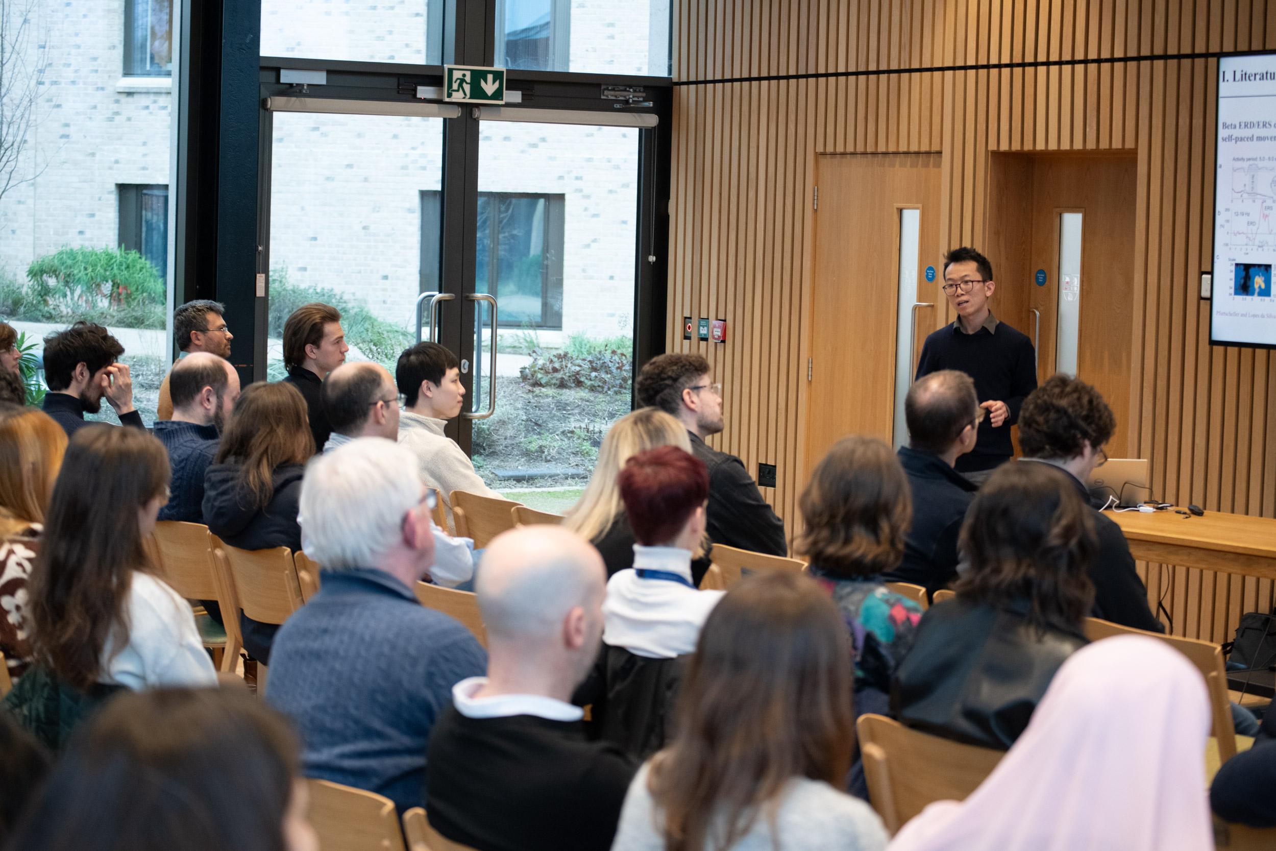 A photo of Shenghong He presenting his research to Unit colleagues.