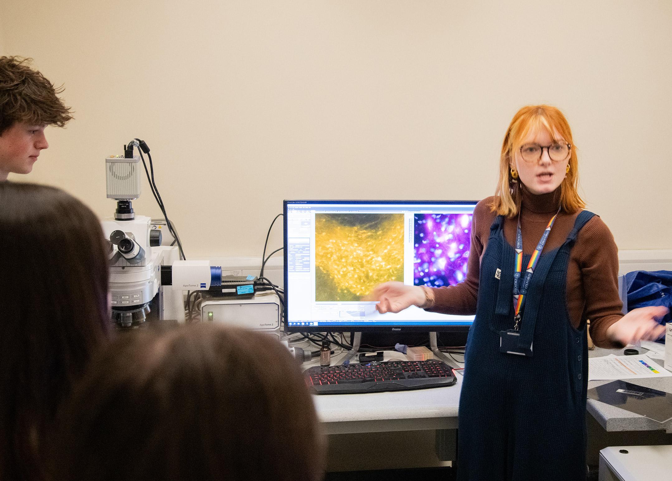 Photo of BNDU researcher Jennifer Blackmore standing next to the confocal microscope.