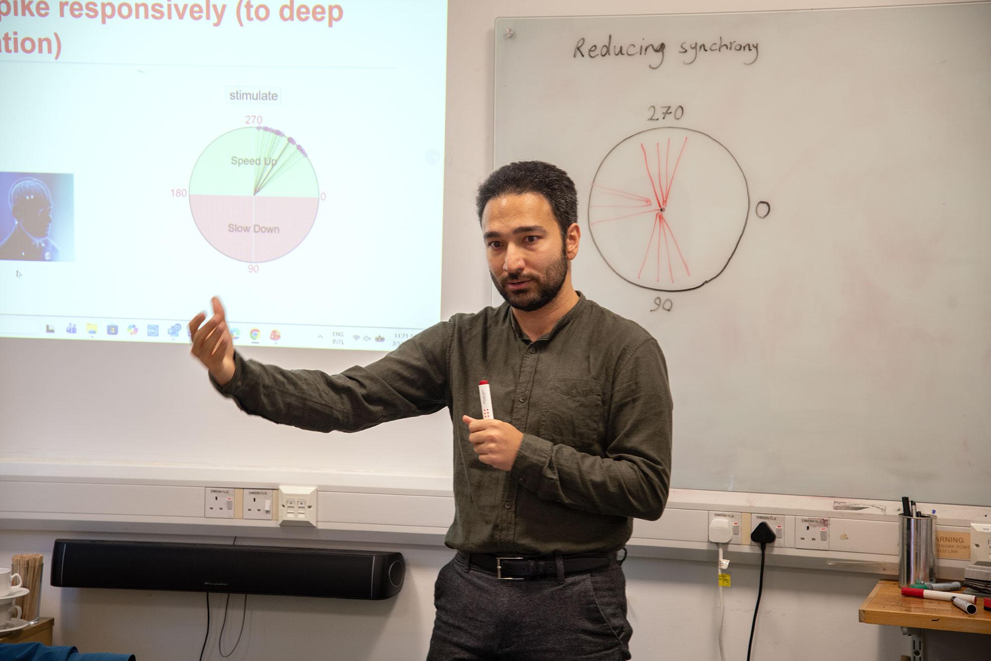 a research stood in front of a projected diagram
